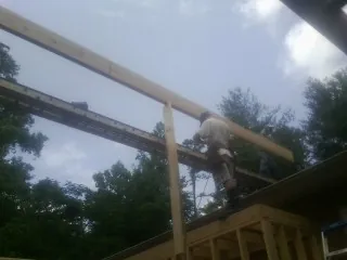 Carpenter setting a ridge beam over a new addition frame — Ice Dam Removal by Roofing Brothers in New Derry
