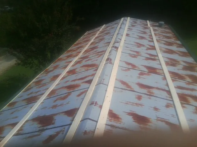 Rusted metal roof panels with new wood purlins before replacement — Storm Damage Roof Repair in New Derry by Roofing Brothers