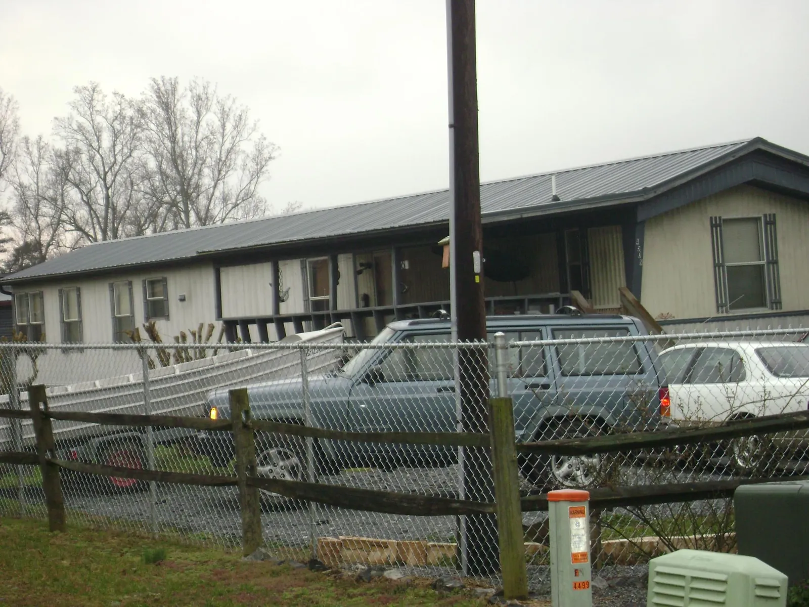 Dark metal roof on a long single story building behind a chain link fence in New Derry