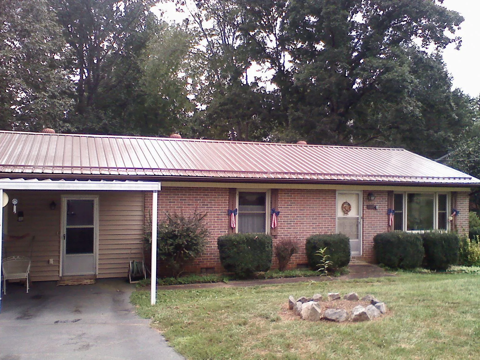 Bronze metal roof and carport on a brick ranch home — Roof Repair work by our crew in New Derry
